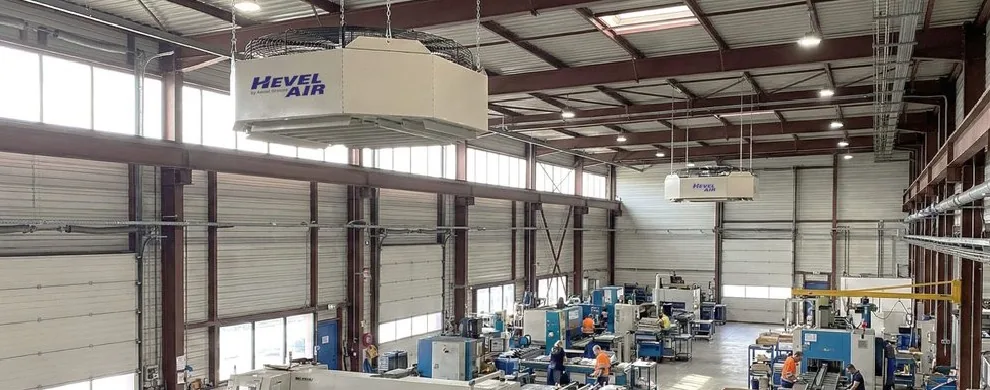 Atelier industriel de grande hauteur équipé de deux déstratificateurs Hevel Air suspendus à la charpente